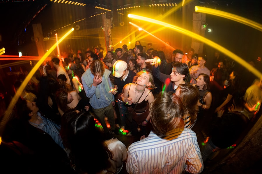 A packed dance floor under sweeping amber lasers